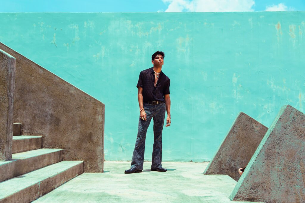 fashion portrait of dark skinned Indian man in concrete surroundings