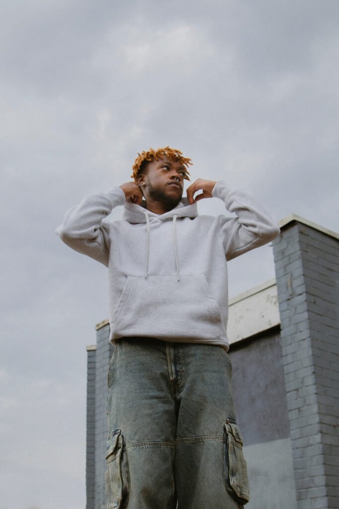 Young black man in street wear posing in the city